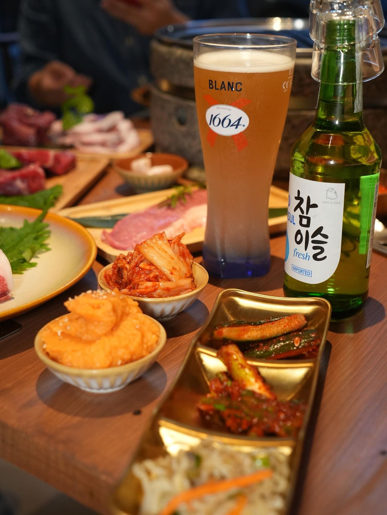 Birra 1664 alla spina e bottiglia di soju Chamisul sul tavolo con i contorni