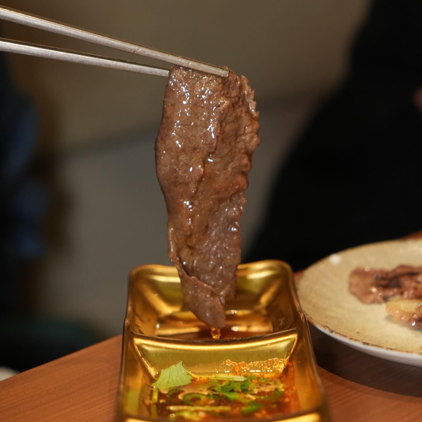 Un pezzo di carne cotta intinto nella salsa con le bacchette