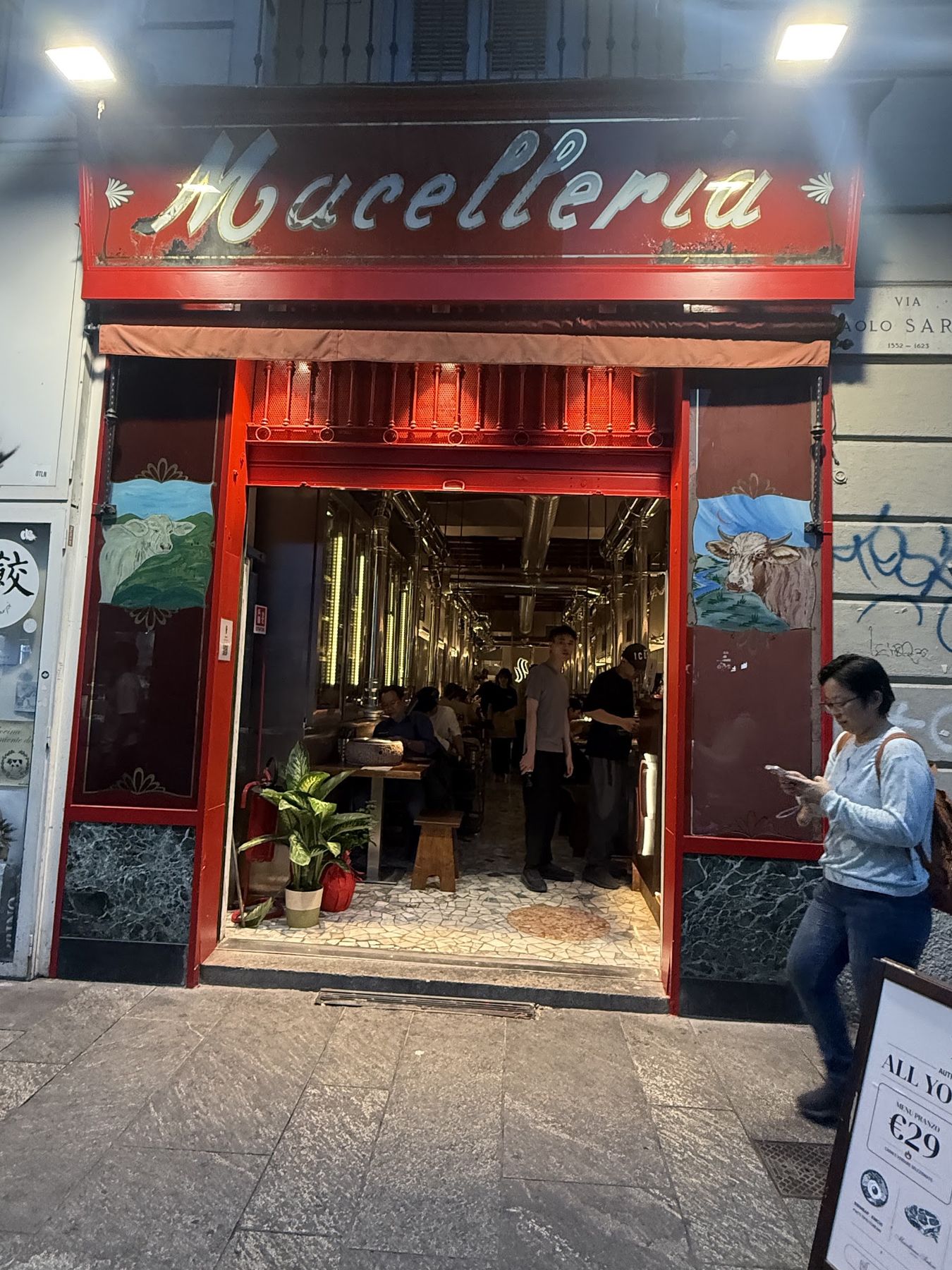 L'ingresso della Macelleria la sera, con la sala illuminata dietro
